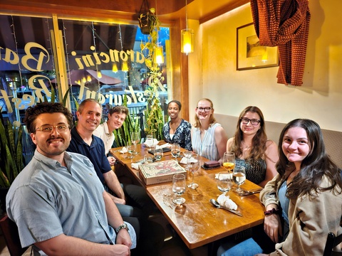 Picture of Brian Nosek and six graduate students seated around a restaurant table