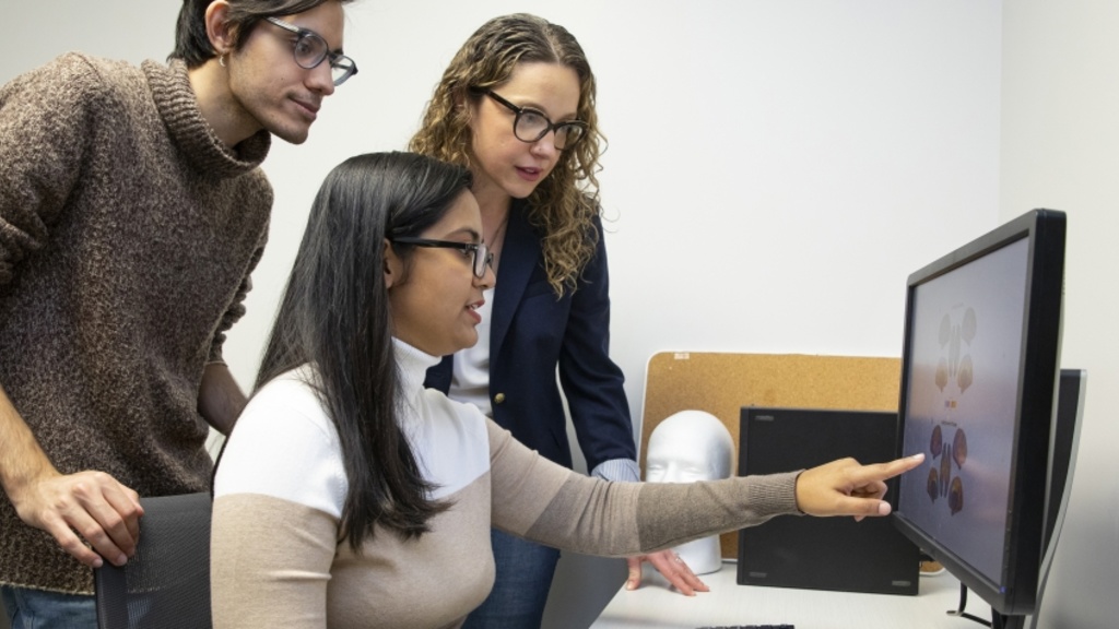 3 people looking at a computer