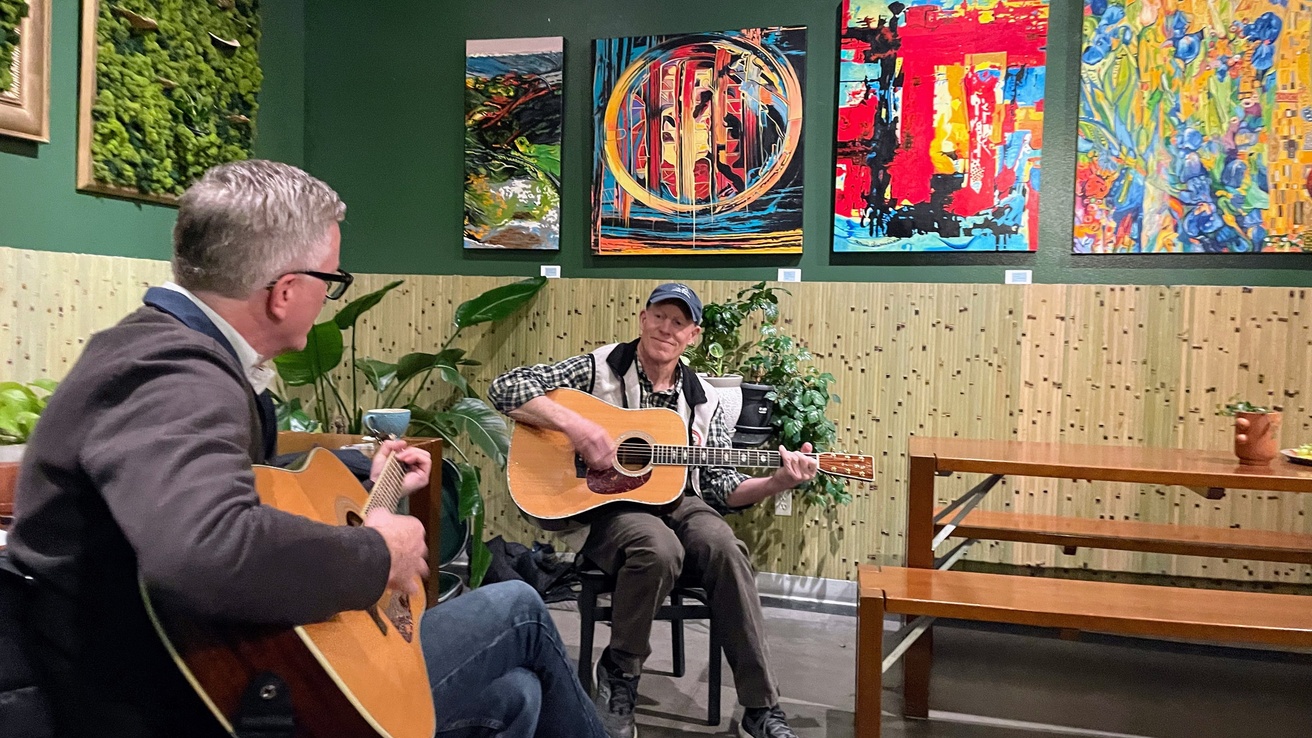 Picture of two BBIP faculty playing guitar in a cozy setting.